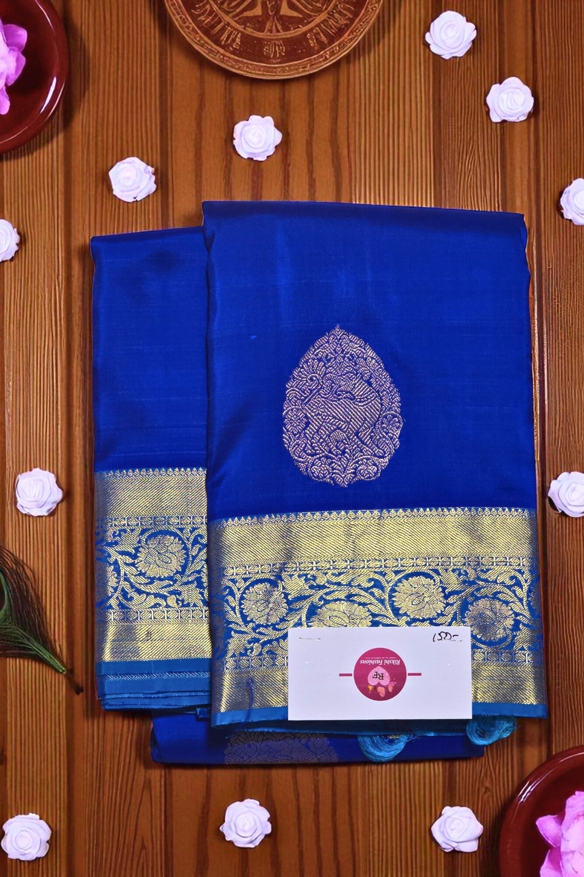 Blue saree with gold border on a wooden surface