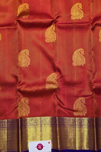 Red fabric with gold patterns and a visible brand label.