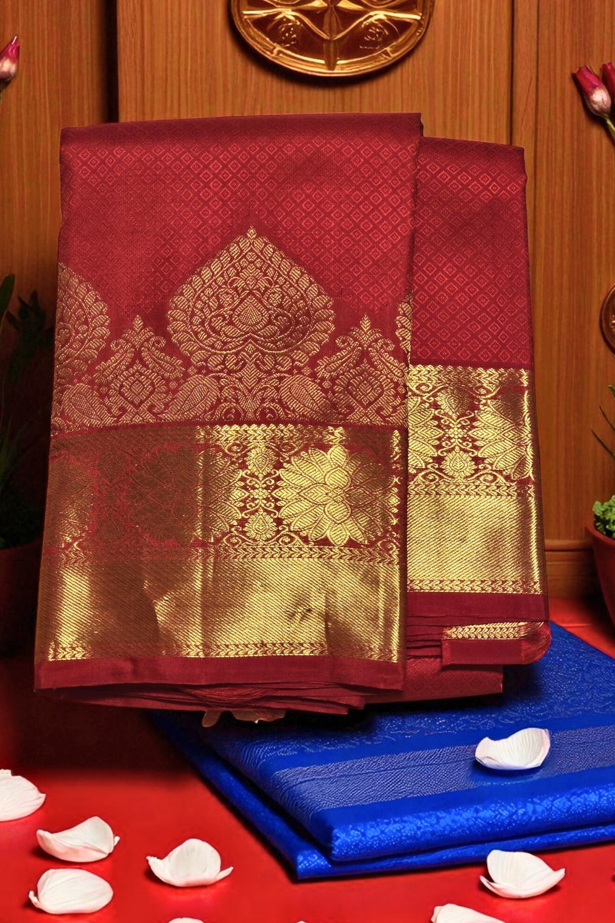 Red and gold saree with blue fabric underneath on a wooden background