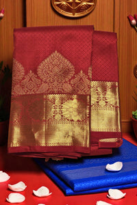 Red and gold saree with blue fabric underneath on a wooden background