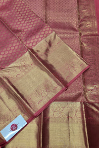 Maroon and gold saree with intricate patterns and a visible brand label.