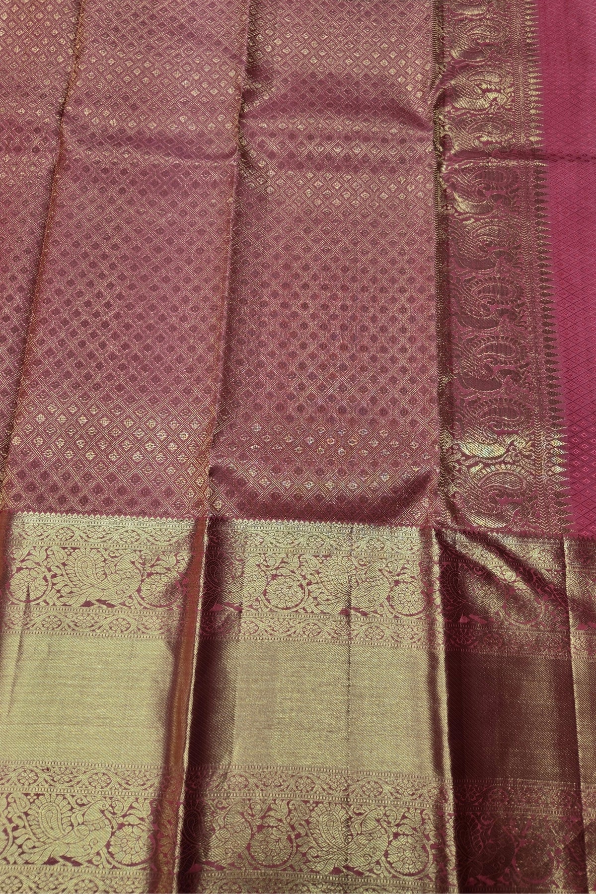 Close-up of a patterned fabric with a maroon and green color scheme.
