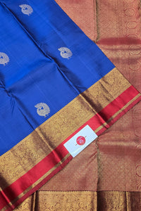 Blue saree with gold and red border featuring a brand label.