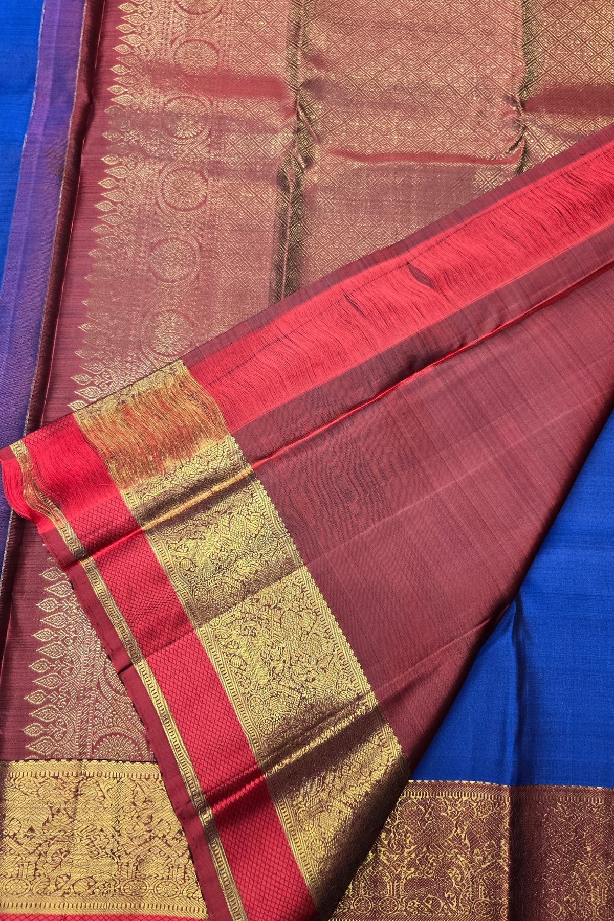 Saree with red and gold border on a blue background