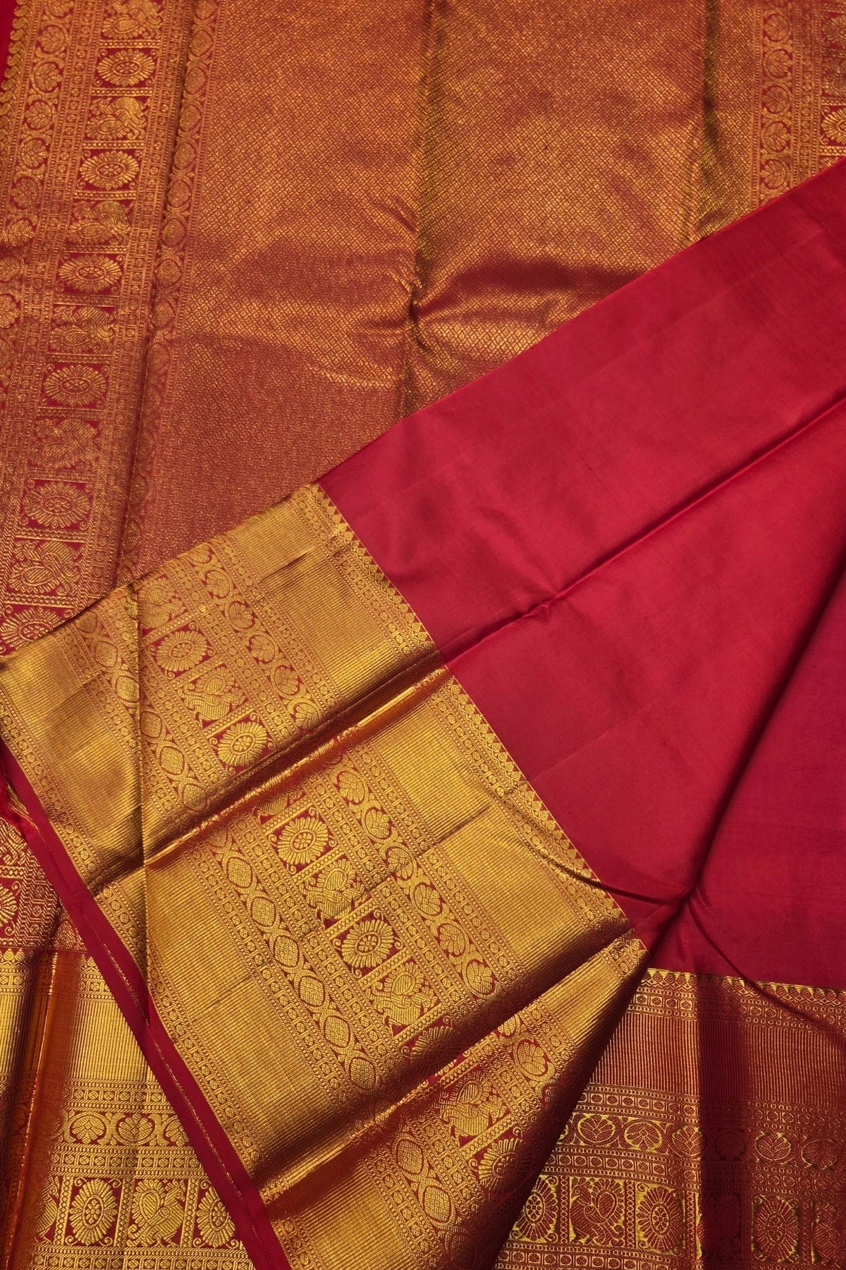 Saree with gold and red fabric, featuring intricate patterns.