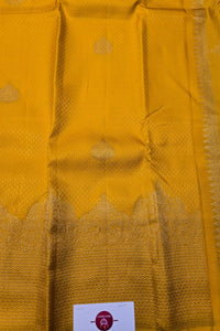 Mustard yellow fabric with a subtle pattern, possibly a traditional textile.