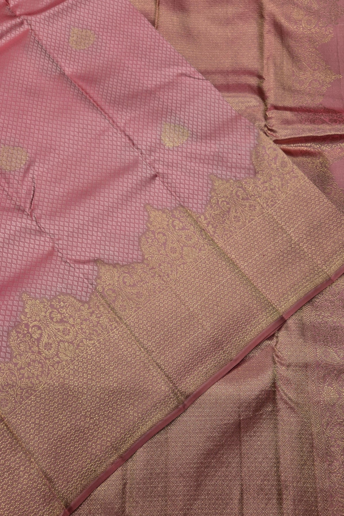 Close-up of a pink fabric with gold embroidery