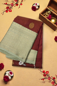Traditional saree with a decorative border on a beige background with floral elements.