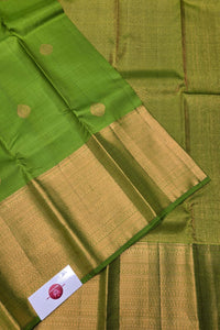 Green and gold traditional fabric with a brand label.