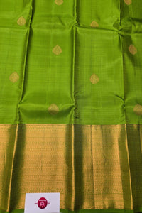 Green fabric with gold patterns and a brand label at the bottom.