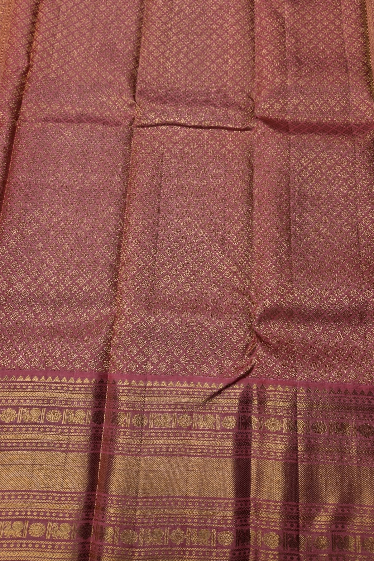 Close-up of a maroon fabric with intricate patterns and a border.