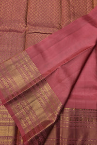 Close-up of a maroon saree with gold border and patterns