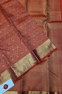 Close-up of a brown and gold saree with a visible brand label.