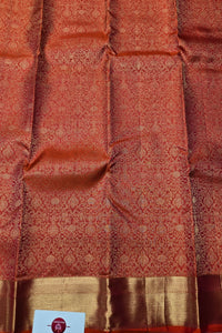 Red and gold patterned fabric with a visible brand label.