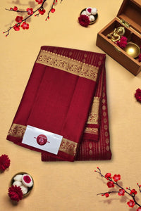 Red saree with gold border on a beige background with decorative elements