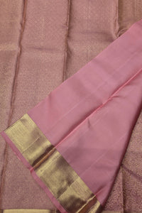 Pink saree with a gold border on a textured brown background