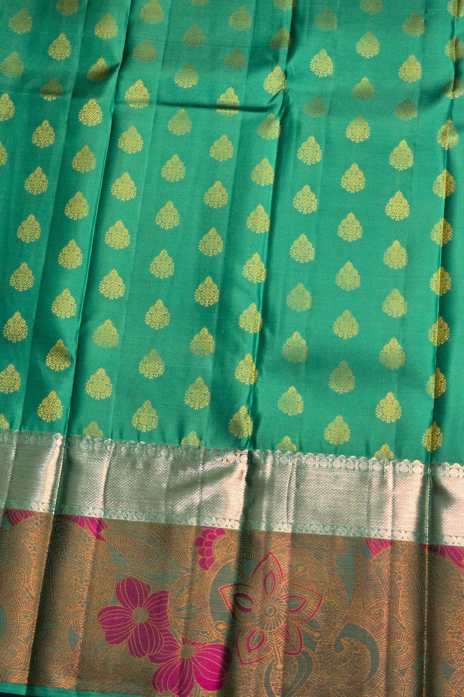Traditional green saree with intricate flower design on border