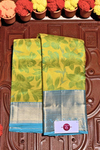 Yellow saree with green floral pattern on a brown textured background