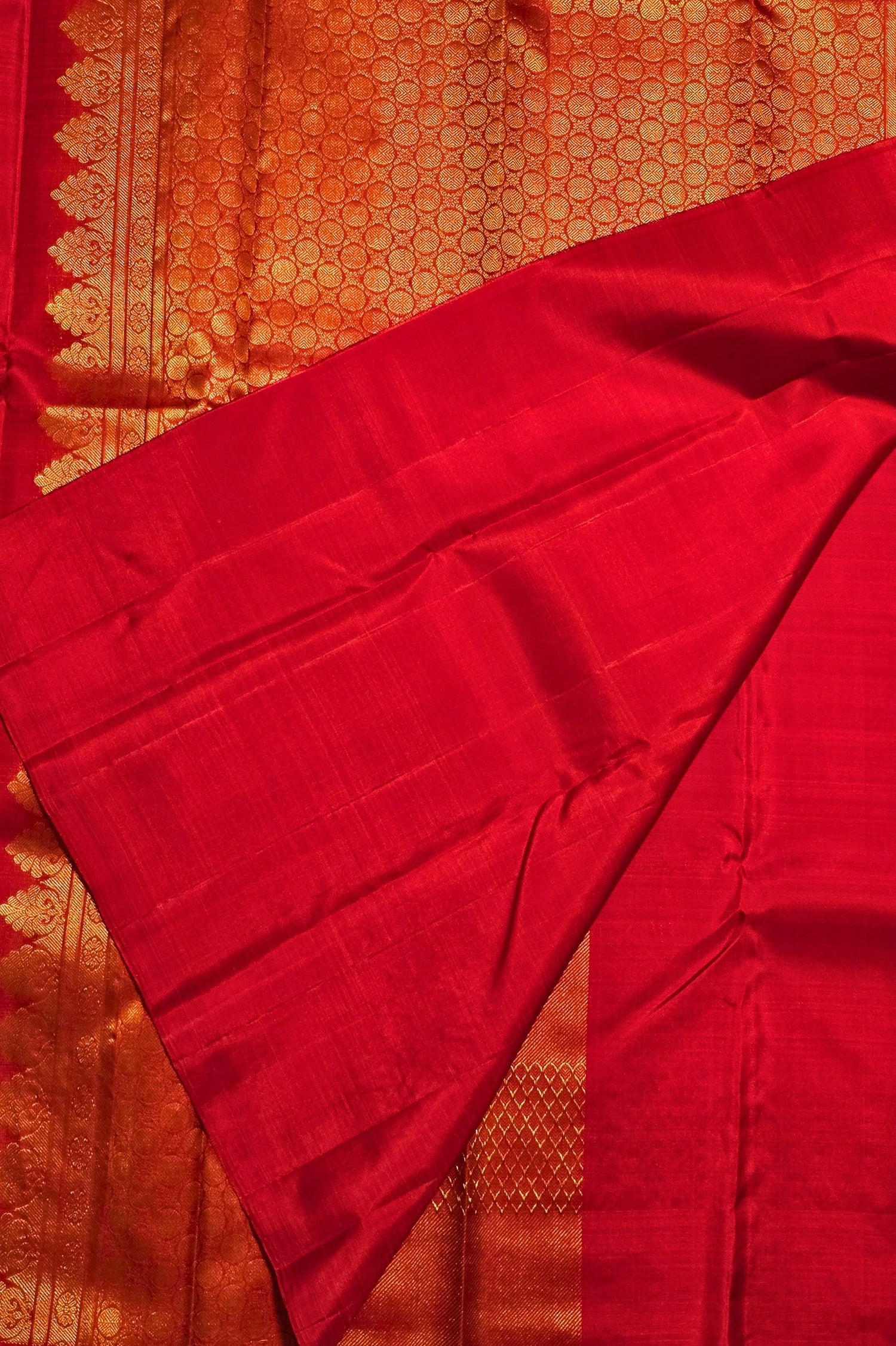 Red fabric with intricate patterns on a textured background