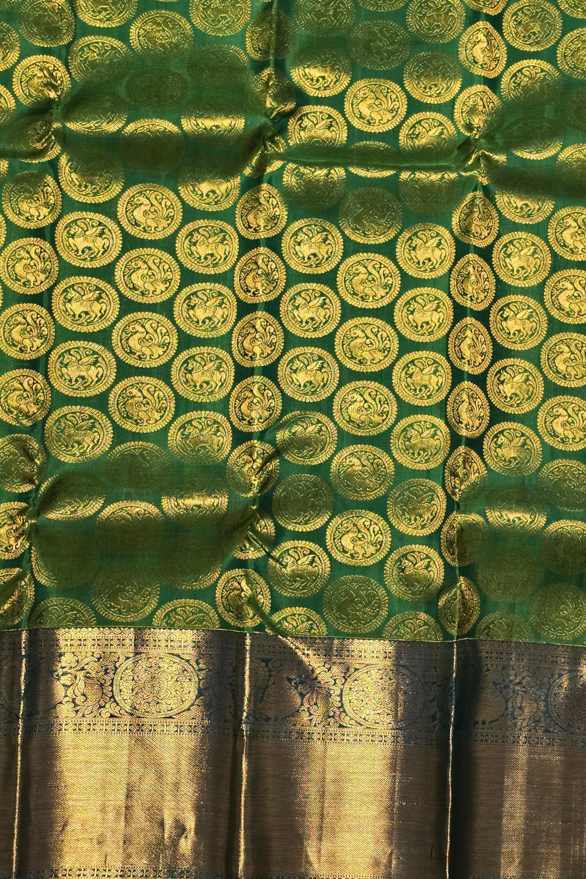 Green fabric with gold circular patterns and a brown border
