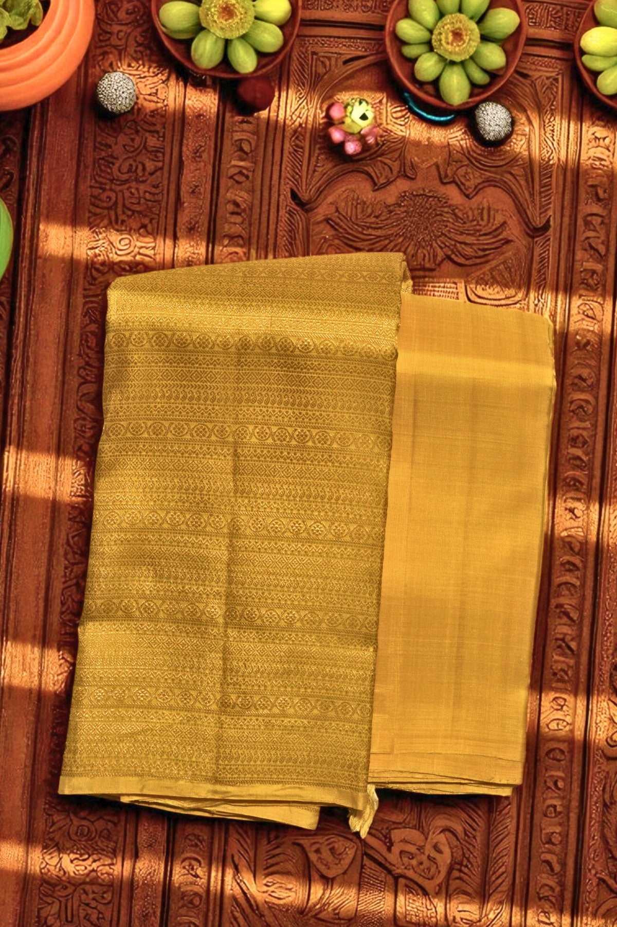 Yellow fabric on a wooden surface with decorative items.