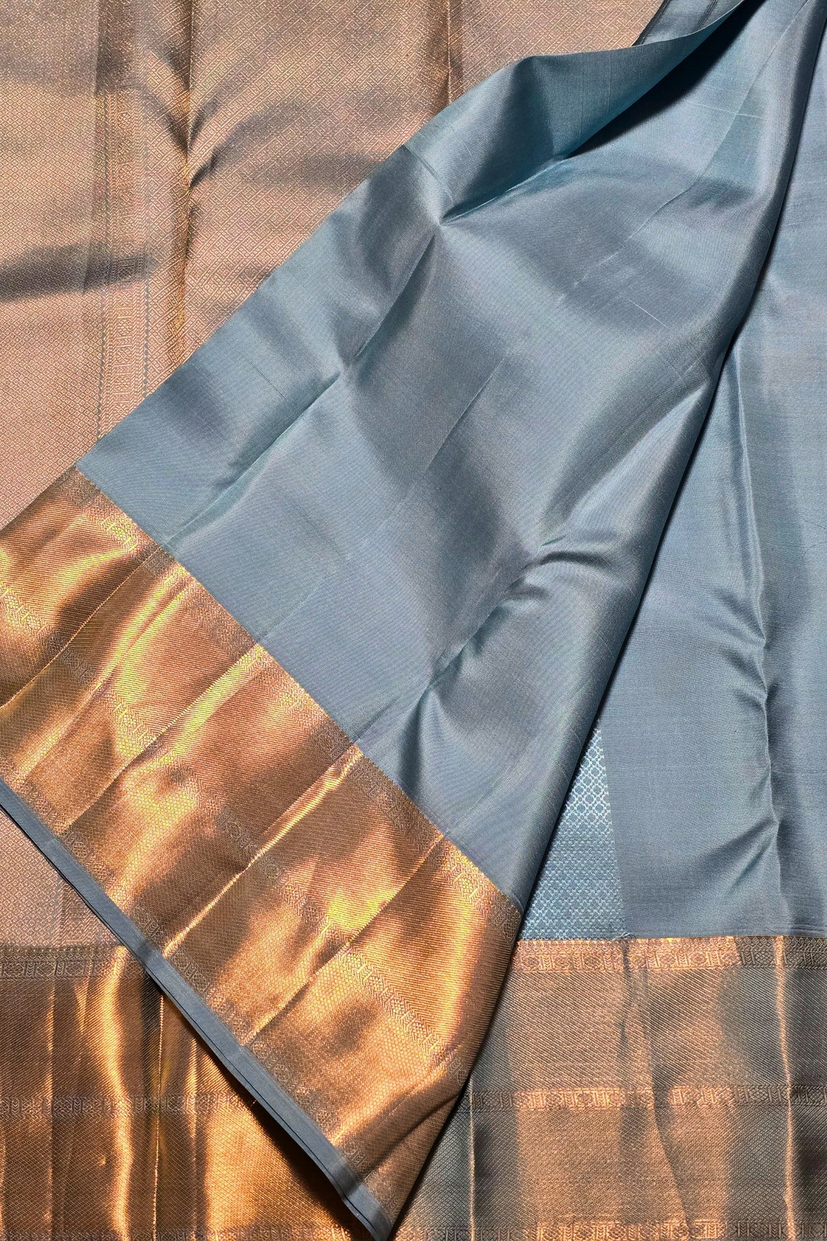 Fabric with blue and gold pattern on a wooden surface