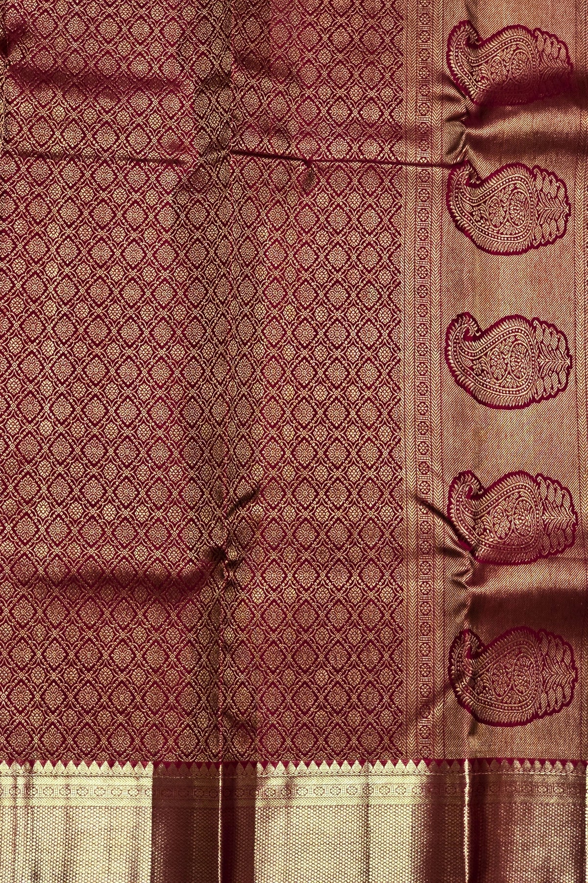 Maroon fabric with intricate patterns and designs