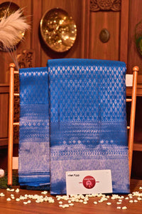 Two blue patterned towels on a wooden chair with decorative elements in the background.