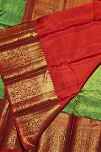 Red saree with gold border on a green background