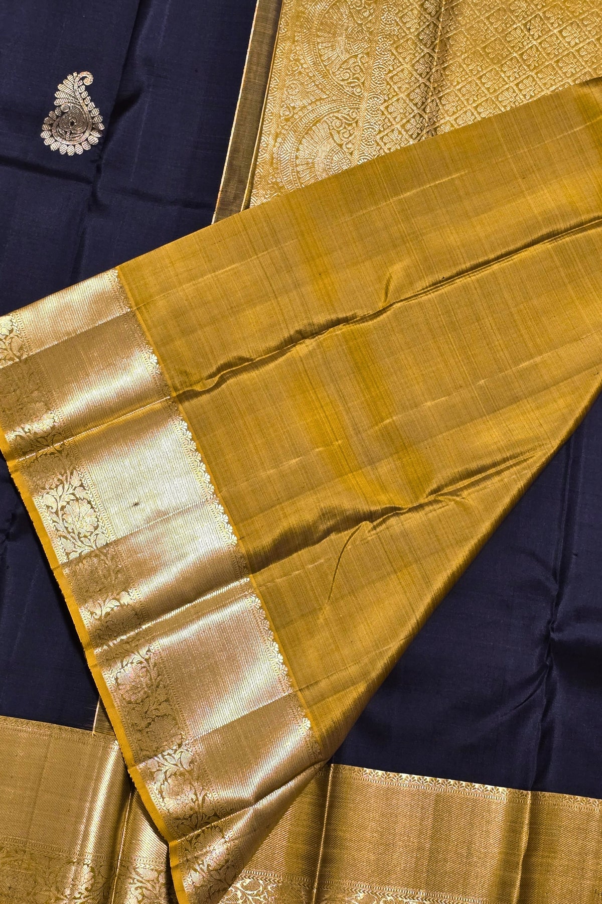 Gold saree with a blue blouse piece on a matching fabric background
