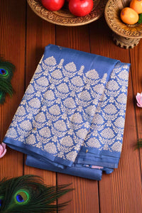 Blue saree with white floral pattern on a wooden surface