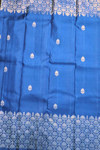 Blue fabric with white floral patterns, possibly a traditional garment.