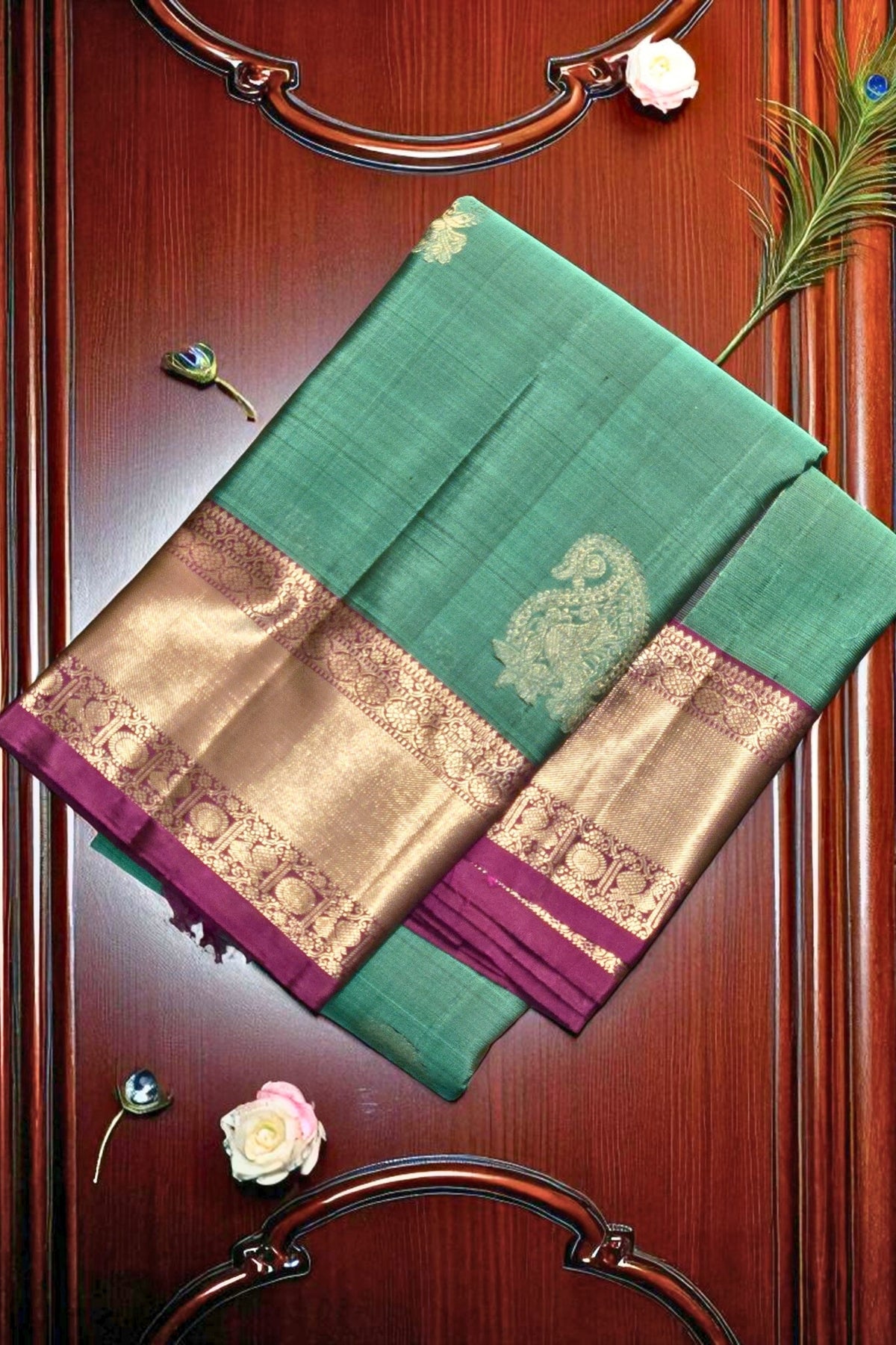 Green and gold saree with floral decorations on a wooden background