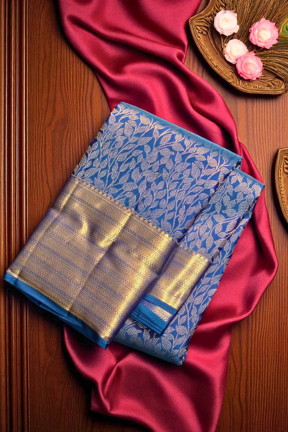 Blue saree with gold border on a red fabric background