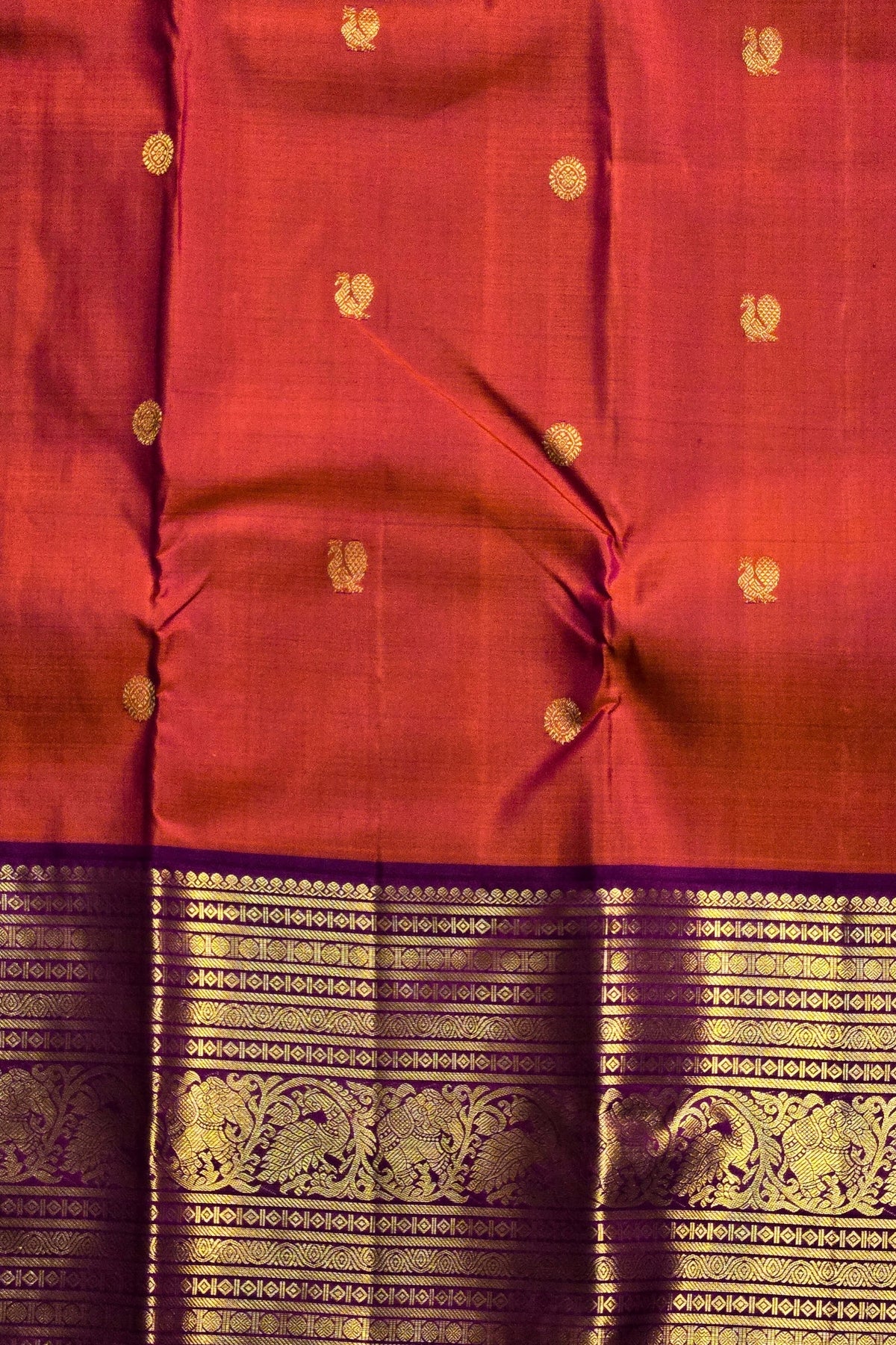 Red fabric with gold patterns and a purple border