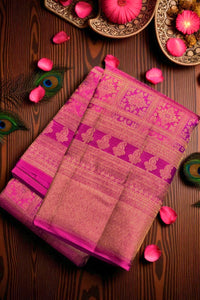 Pink and brown saree with intricate patterns on a wooden surface with decorative elements.