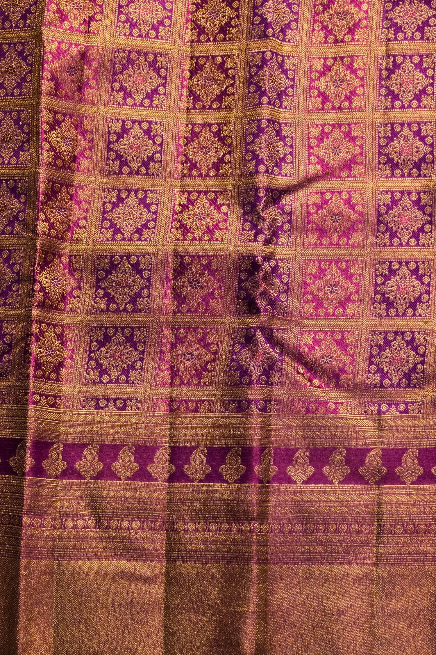 Close-up of a fabric with intricate purple and gold pattern