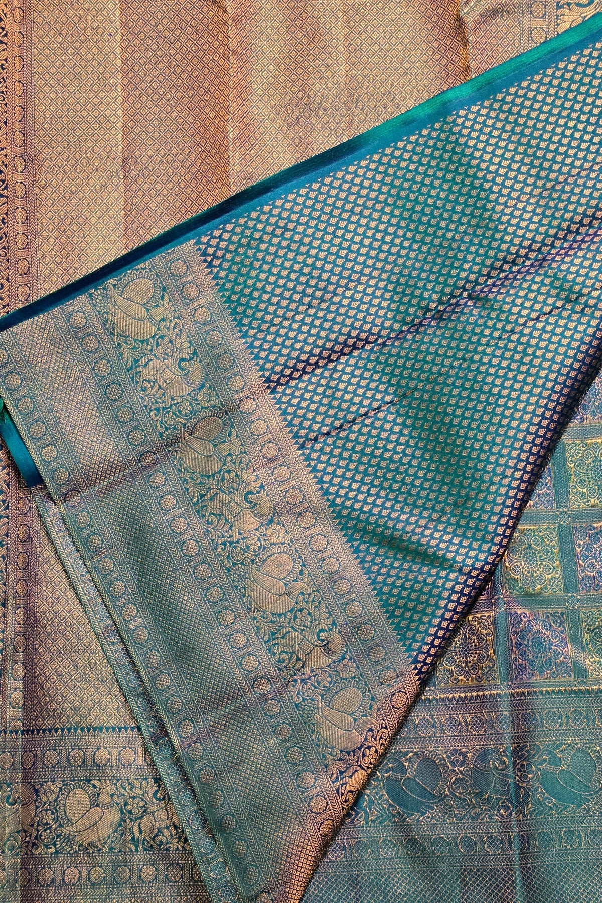 Close-up of a patterned fabric with teal and gold colors