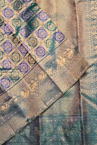Close-up of a patterned fabric with intricate designs in blue, green, and gold.