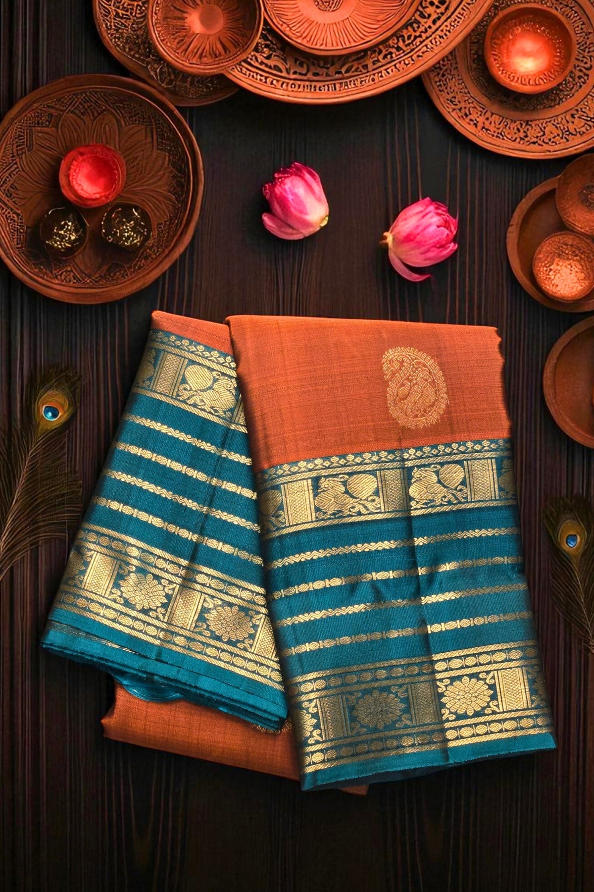 Two sarees with blue and orange patterns on a dark surface with decorative items.