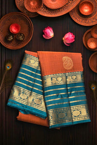 Two sarees with blue and orange patterns on a dark surface with decorative items.