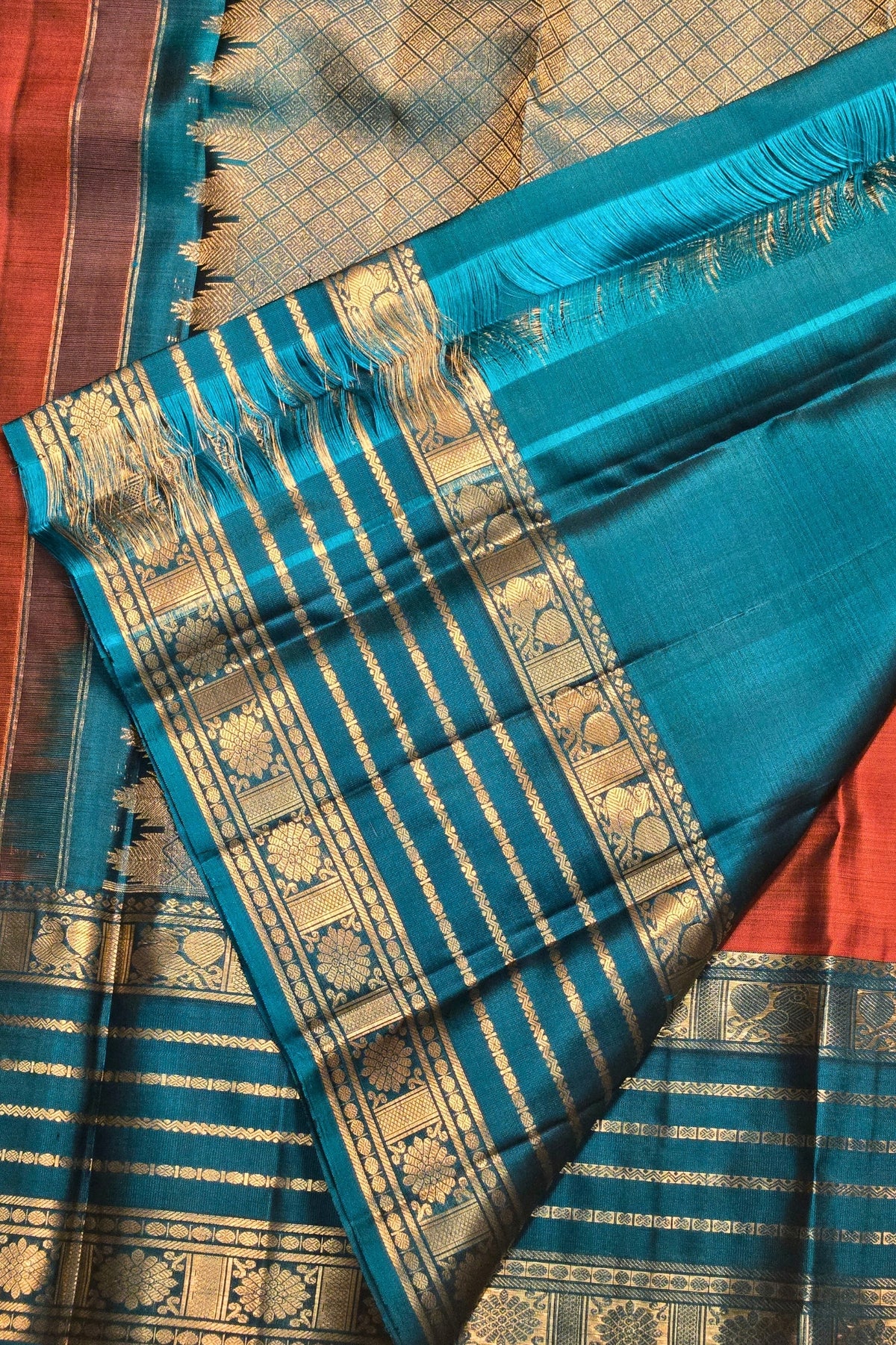 Blue saree with gold patterns on a red background