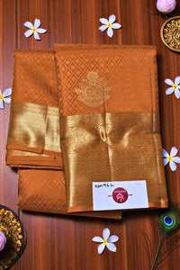 Brown saree with gold border on a wooden background with decorative elements