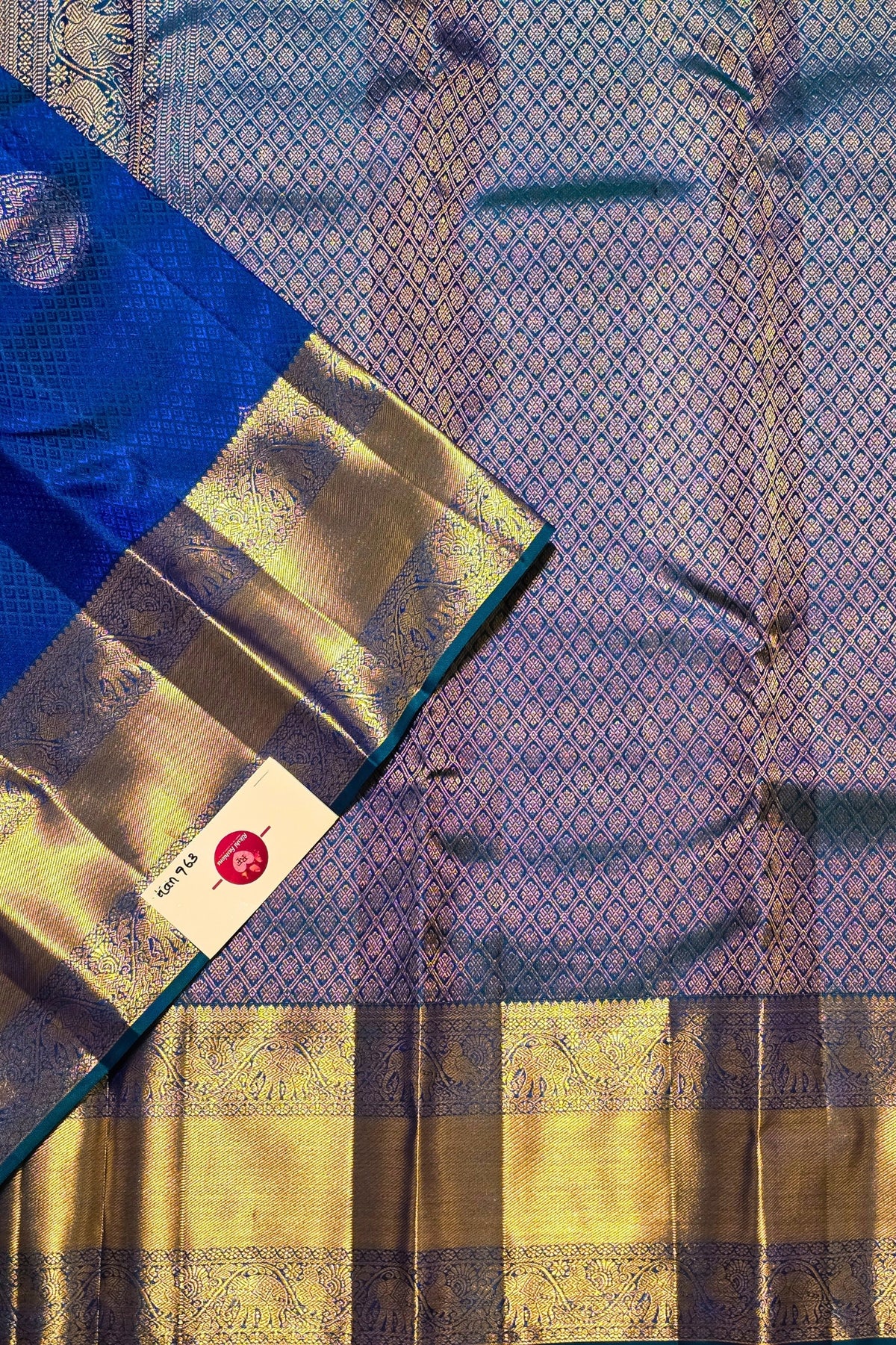 Blue and gold saree with a visible brand label on a patterned background
