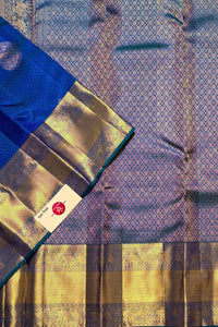 Blue and gold saree with a visible brand label on a patterned background