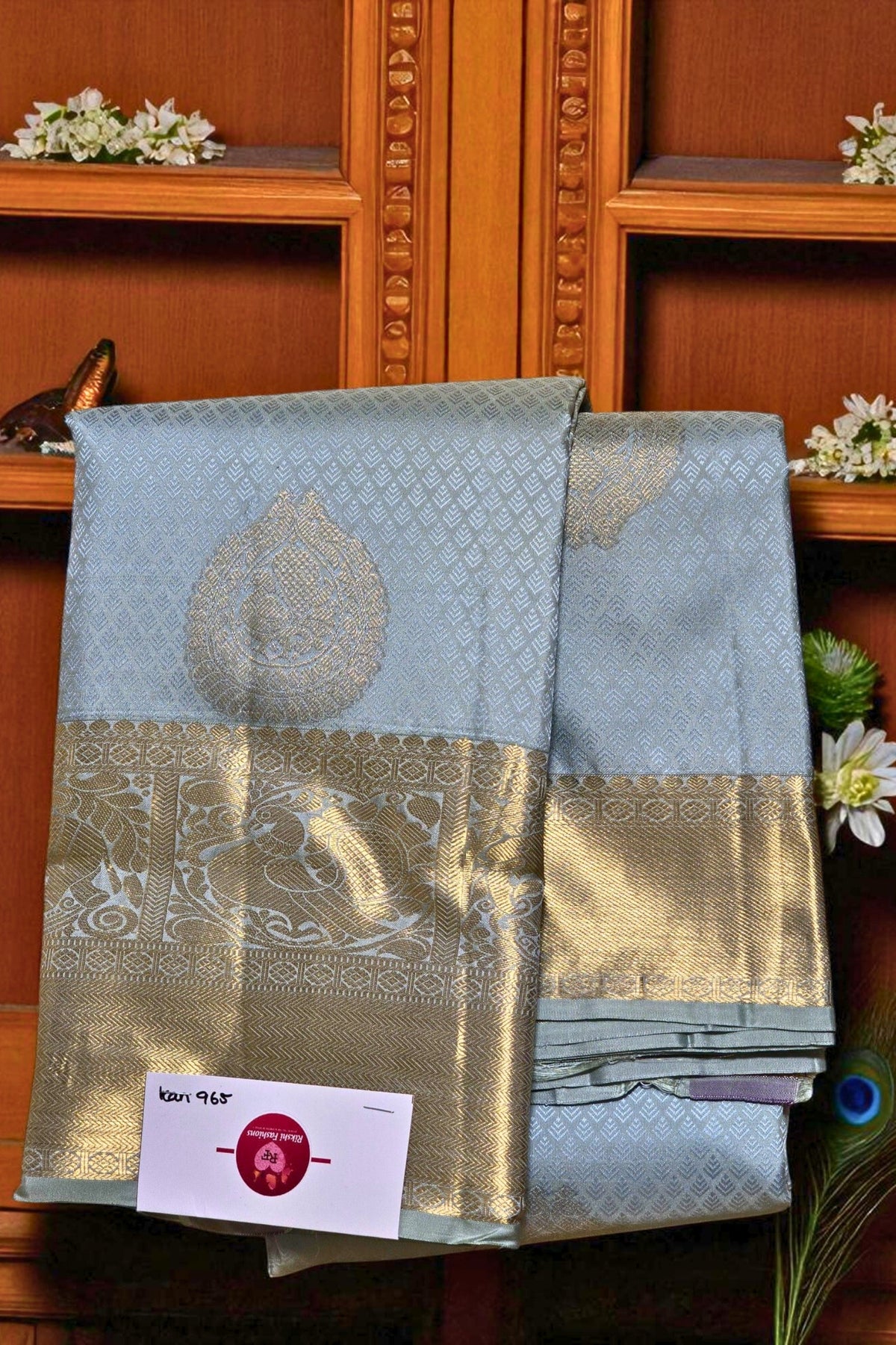 Light blue saree with gold border on a wooden shelf