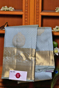 Light blue saree with gold border on a wooden shelf
