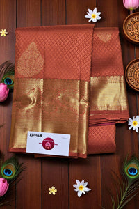 Brown and gold saree with a brand label on a wooden background