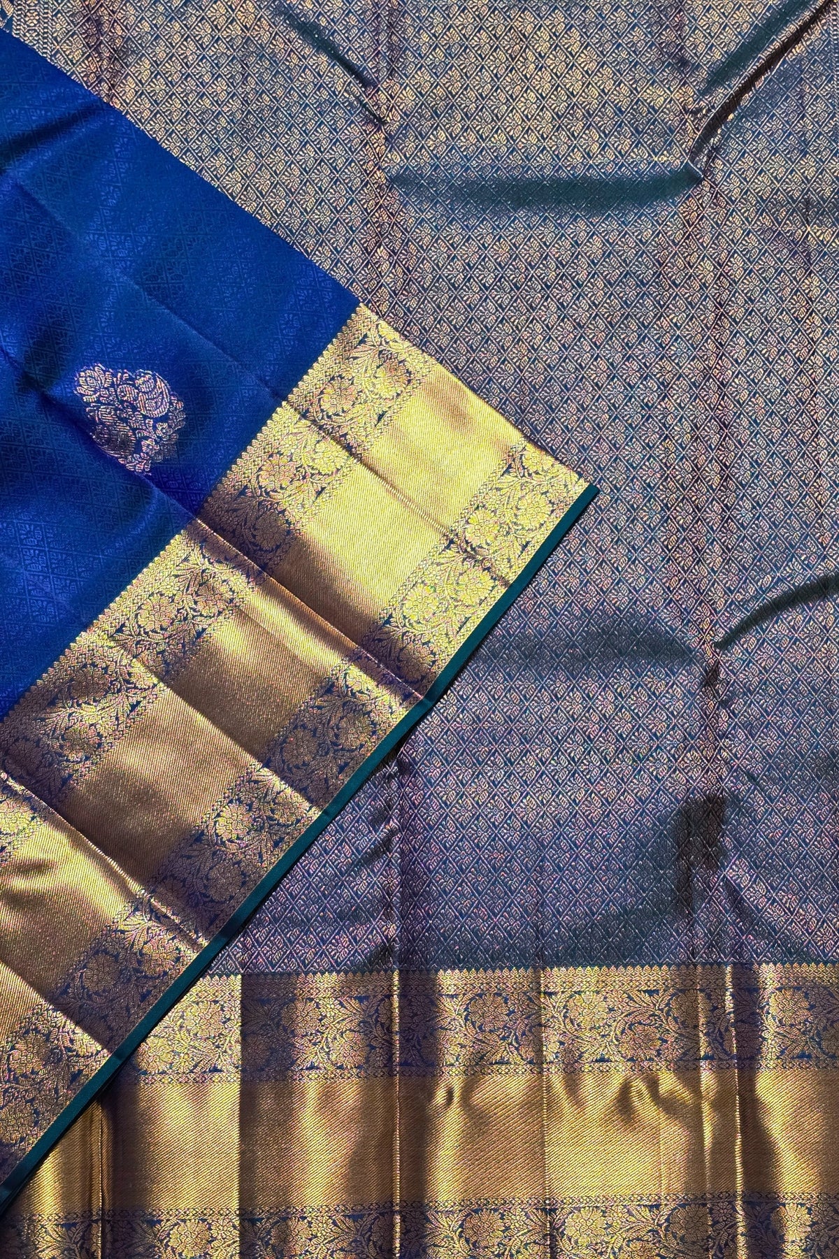 Close-up of a blue and gold saree with intricate patterns