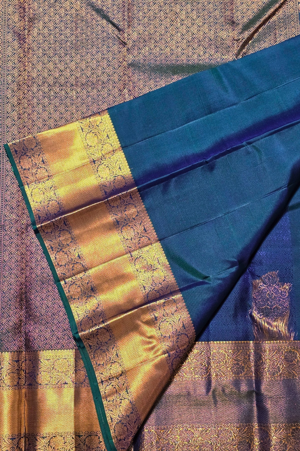 Blue and gold saree with intricate patterns on a textured fabric background
